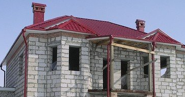 Элегантный классический дом с изящными мансардными окнами и балконами.
